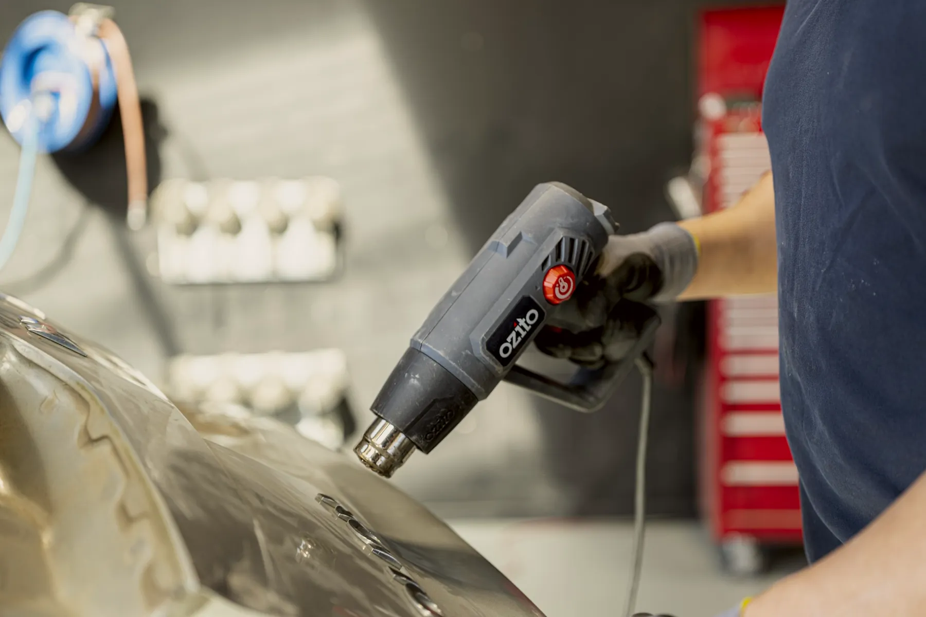 Warming a dented panel with a heat gun at Fix Auto Hamilton South