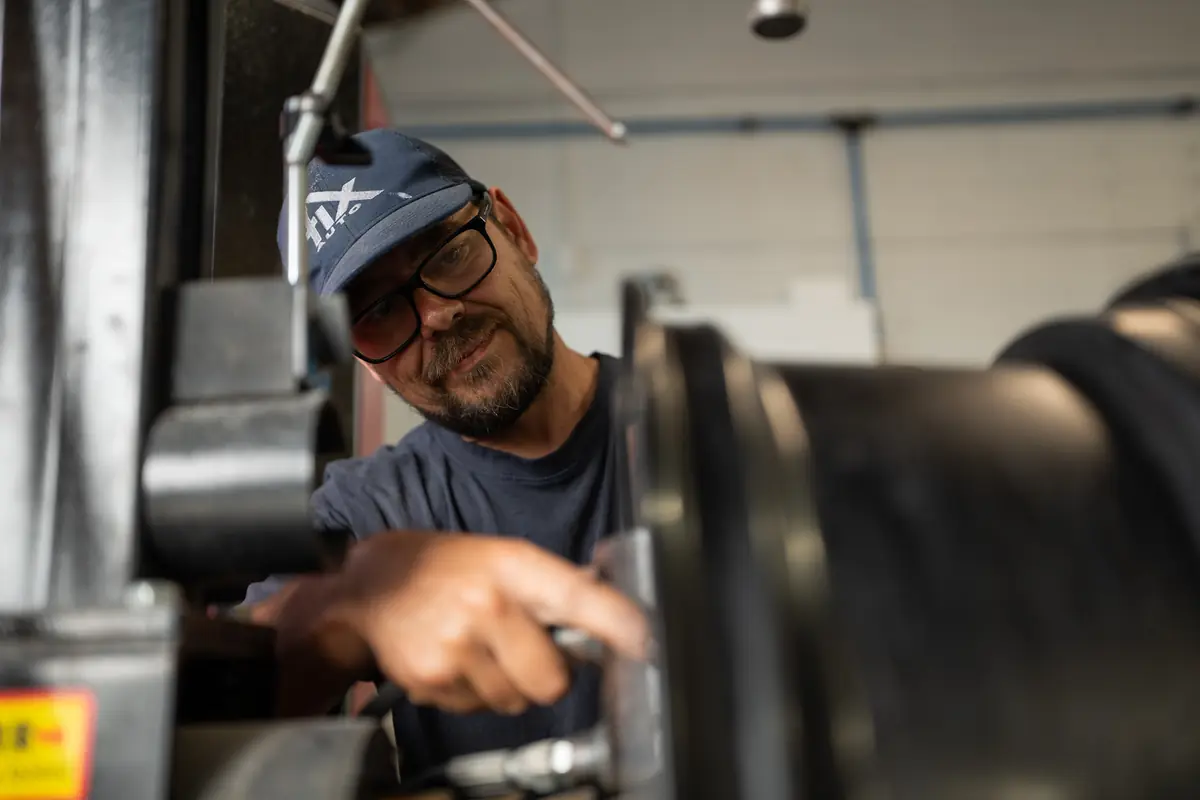 Technician machining an alloy wheel on the CNC lathe at Fix Auto Penrose
