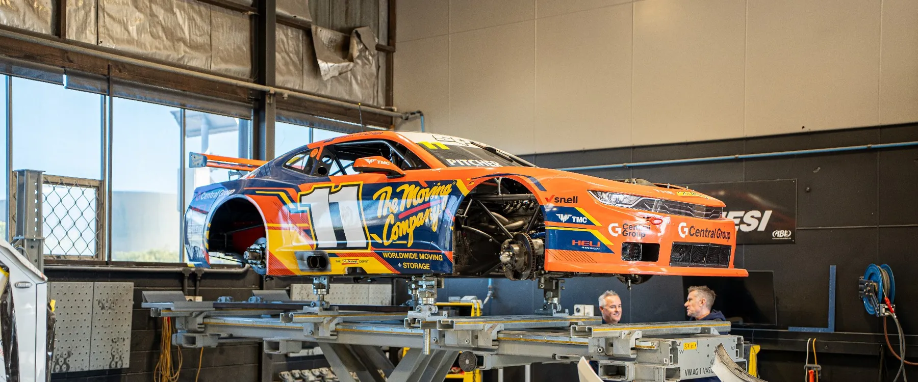 A race car on the lift inside the Fix Auto Hamilton South workshop