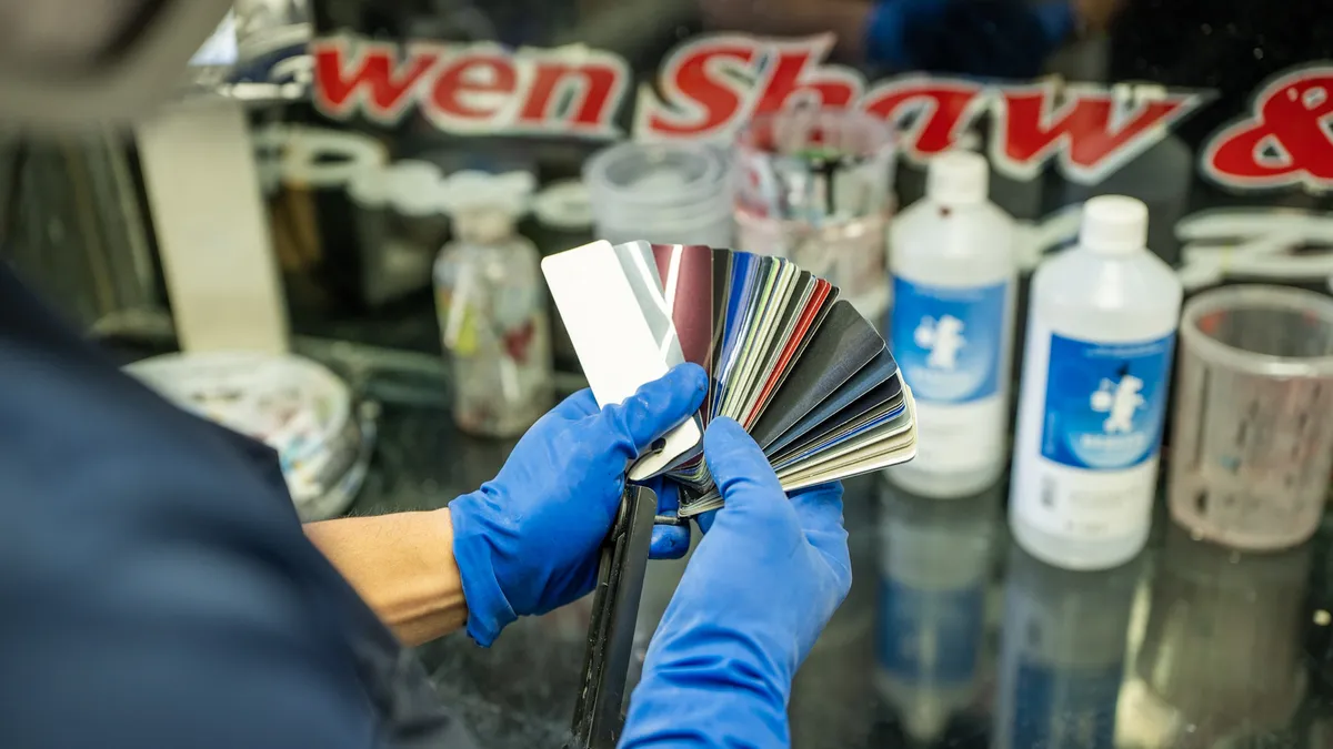 Colour matching in the paint room, under the old Owen Shaw sign
